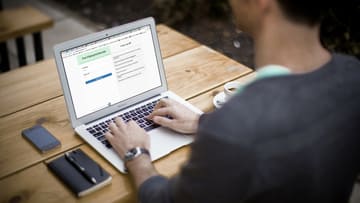 Mann während Onlinesprechstunde am Laptop